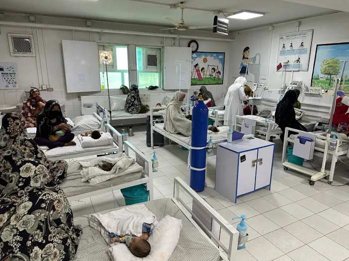 Overzicht van de uitgebreide afdeling in het voedingscentrum van het Boost-ziekenhuis in Afghanistan, waar ernstig ondervoede kinderen op gevulde ziekenhuisbedden liggen.