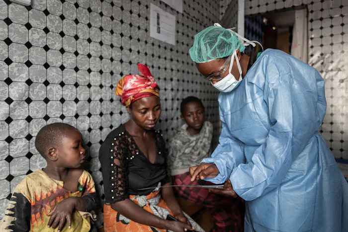 Verpleegkundige Artsen zonder Grenzen legt de symptomen van mpox uit, DRC 2024