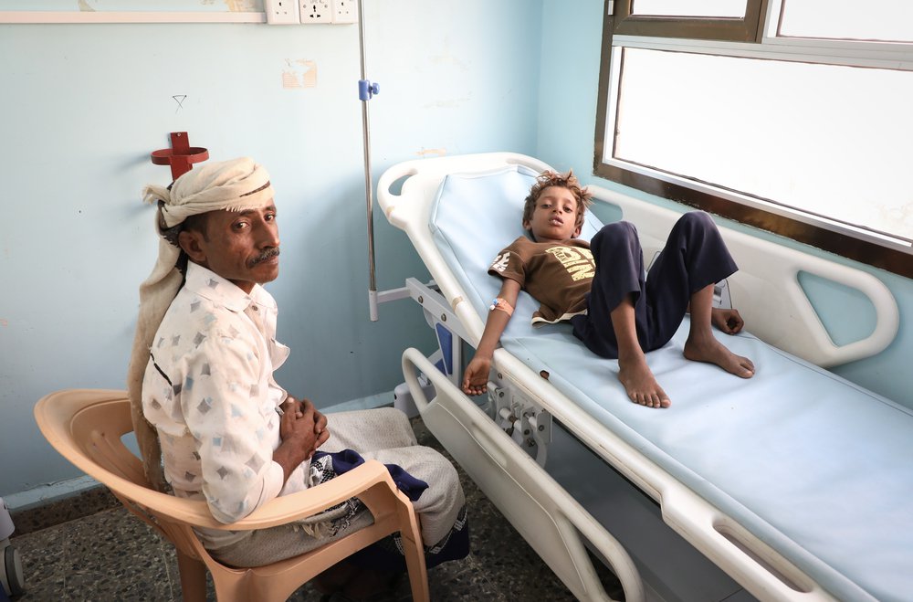 Vader en zoon, patientje in ziekenhuisbed in jemen