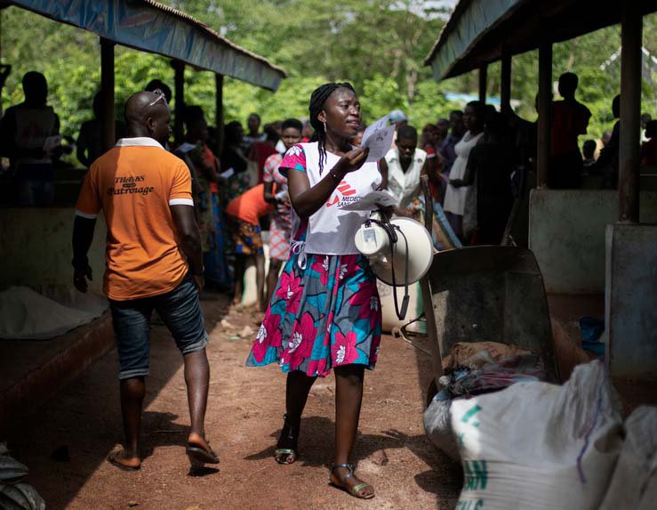 Gezondheidsvoorlichter loopt over de markt en vertelt mensen over de ziekte lassakoorts