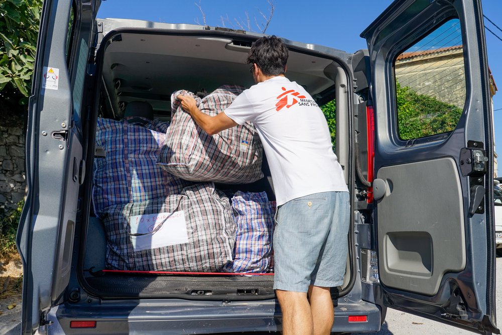 Hulpverlener laadt de auto in met kits voor medische noodhulp.
