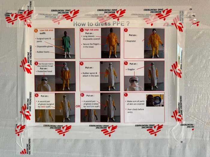 Uitleg hoe je beschermende kleding aantrekt in ebolacentrum in Mongbwalu