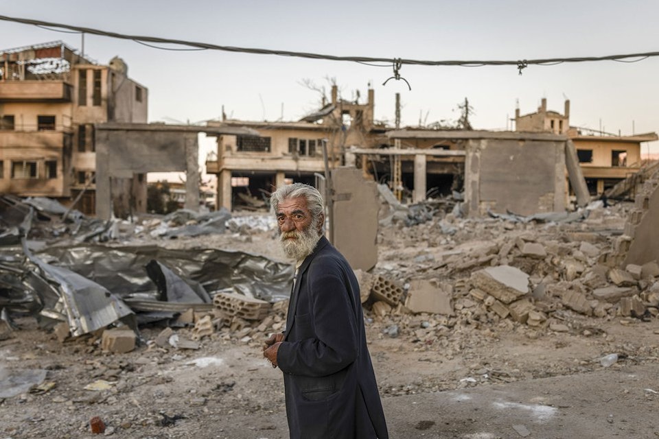 Een man in Libanon in een verwoeste woonwijk.