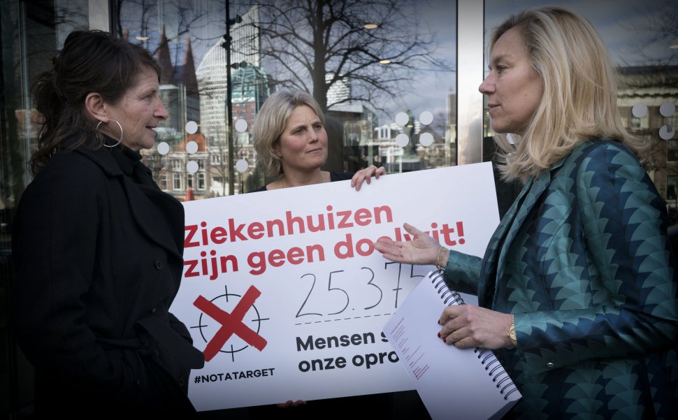 Adjunct-directeur van Artsen zonder Grenzen Katrien Coppens (links) biedt de petitie # NotATarget aan minister Sigrid Kaag (rechts) aan