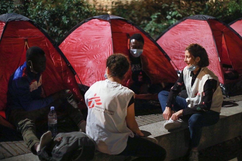 Verpleegkundigen Artsen zonder Grenzen in gesprek met twee jongens die in Parijs op straat leven.