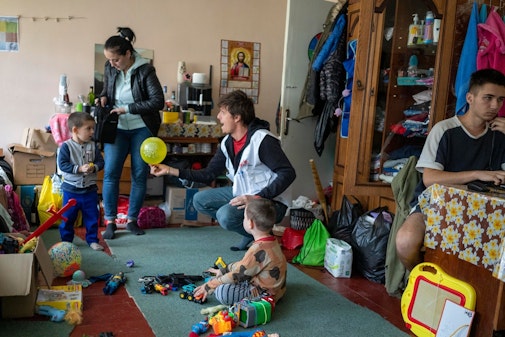 Man speelt met gevluchtte kinderen in Oekraïne