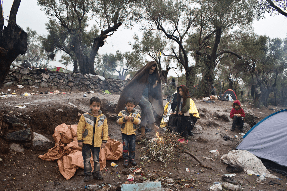 Afghaans vluchtelingengezin wacht in de regen bij het Moria-opvangcentrum op Lesbos