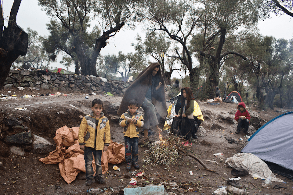 Afghaans vluchtelingengezin wacht in de regen bij het Moria-opvangcentrum op Lesbos