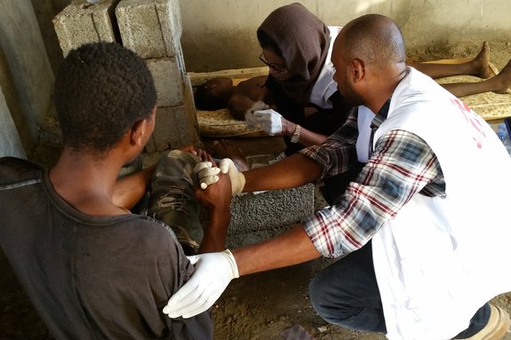 Twee verpleegkundigen helpen een patiënt in Libië.