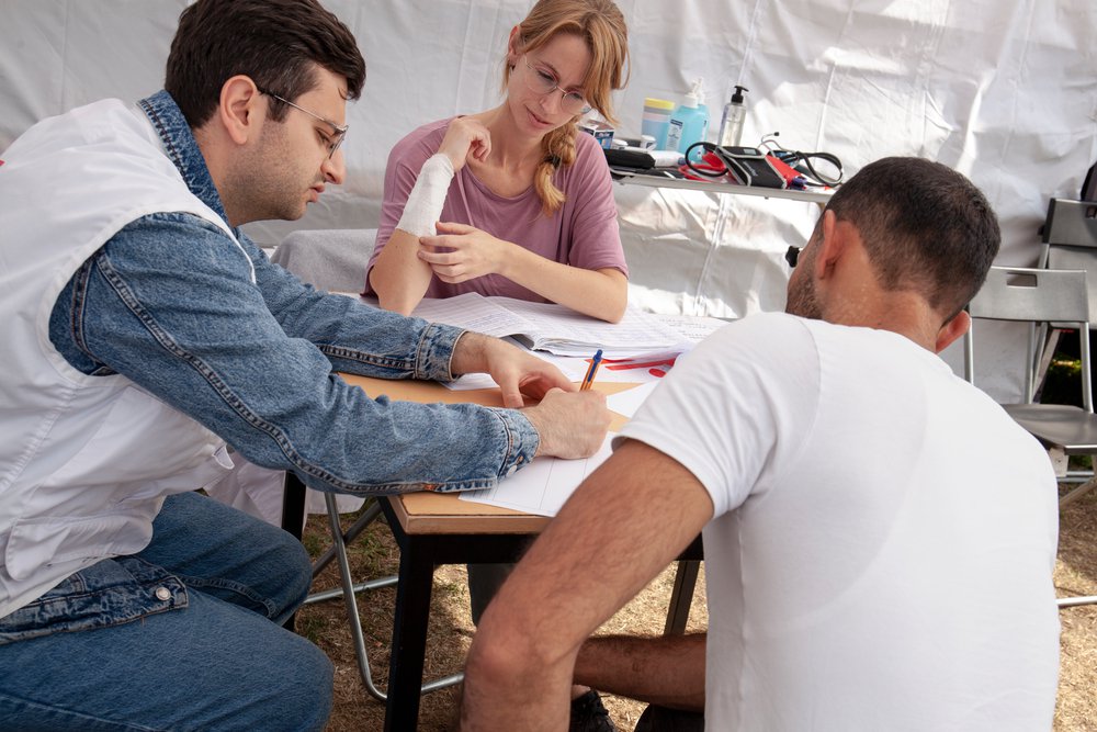 Een patiënt heeft een consult met Samer Sleaby en Hanne Beernaerts in de mobiele kliniek van Artsen Zonder Grenzen in Ter Apel.