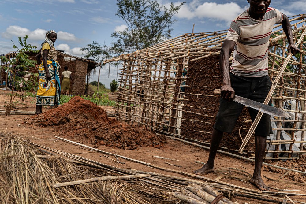 Man bouwt hut in vluchtelingenkamp in Mozambique
