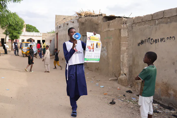 Een gezondheidsvoorlichter van Artsen zonder Grenzen geeft via een megafoon informatie over difterie en vaccinatie in Kano, Nigeria