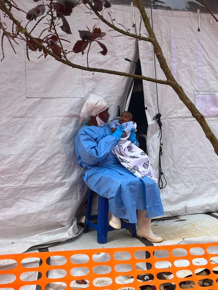 Francine en Asante voor de tent voor baby’s die ziek zijn door ebola.