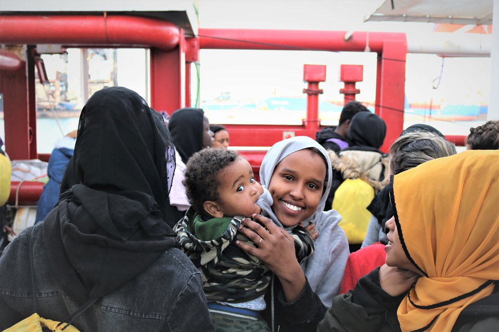 Moeder Brakhedo met haar 11-maanden oude zoontje Aeden op het dek van reddingsschip de Ocean Viking.