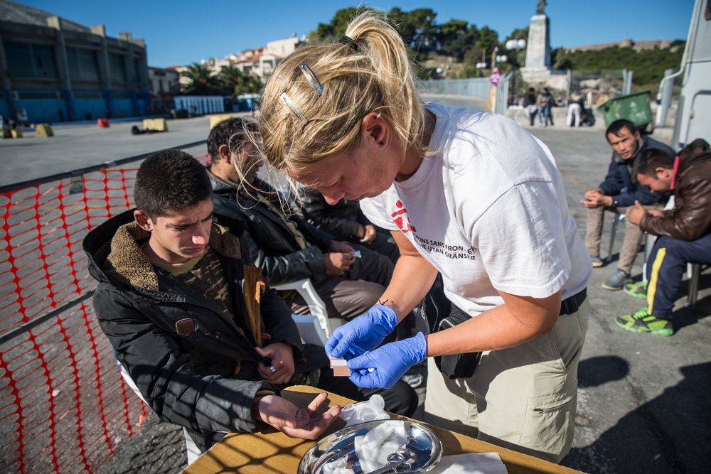 Verpleegkundige Artsen zonder Grenzen behandelt een jongen in de haven van Lesbos