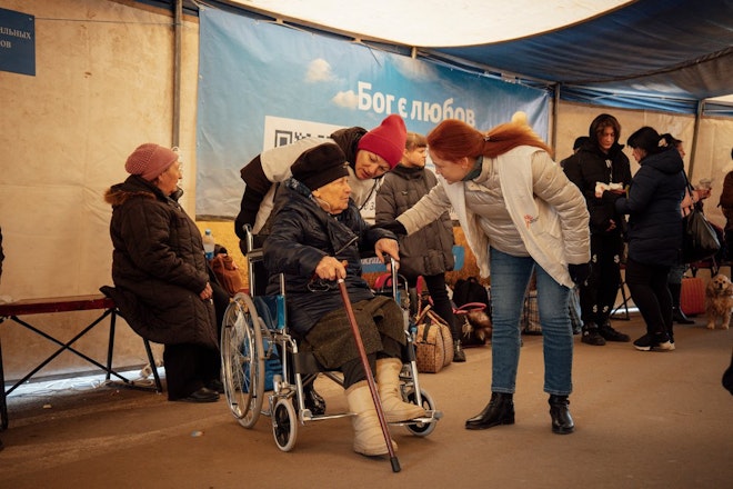 Een medewerker van Artsen zonder Grenzen in gesprek met een groep mensen in Oekraïne.