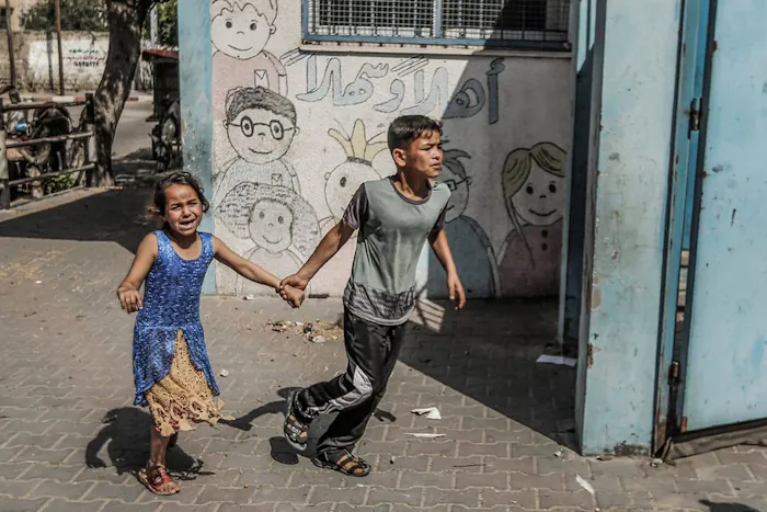 Twee kinderen rennen over een straat in Gaza.