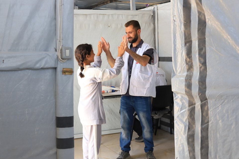 Een psycholoog van Artsen zonder Grenzen met een kind in een kliniek in Gaza.