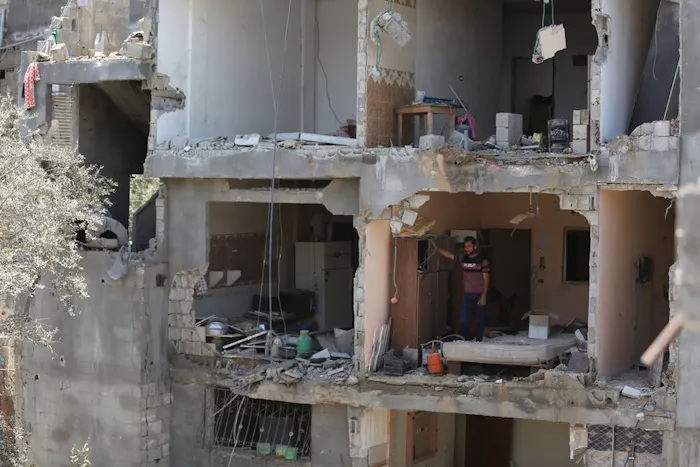 Een man staat in een verwoest appartement in Gaza.