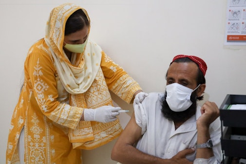 Verpleegkundige dient hepatitis C-medicatie toe aan patiënt in Pakistan.