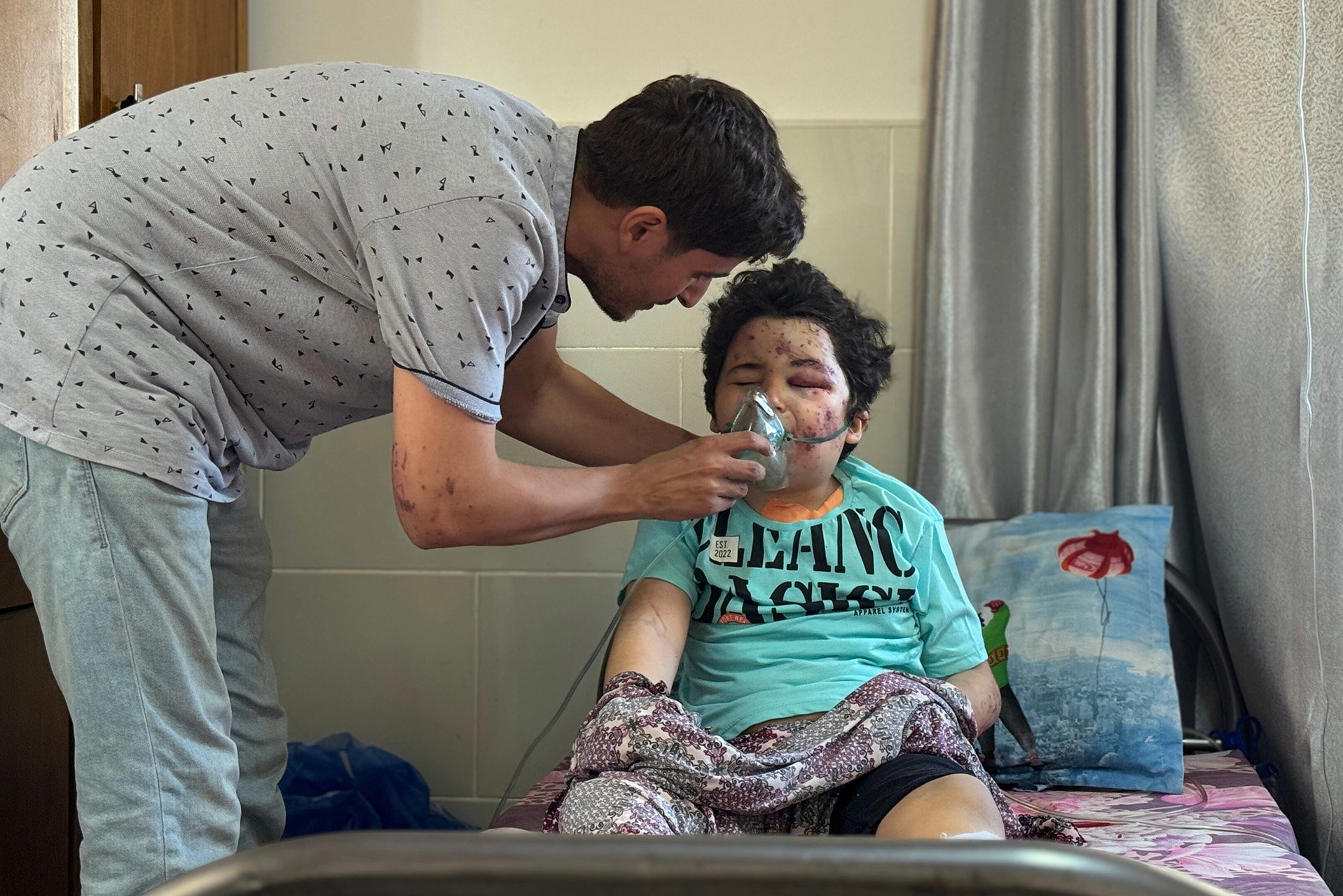 Een hulpverlener helpt een gewond kind in Gaza.