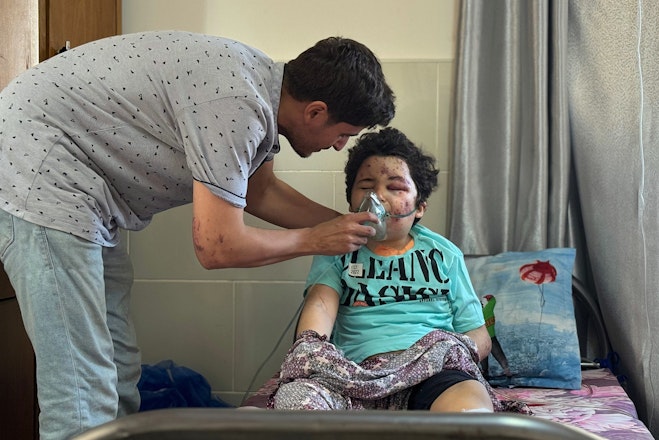 Een hulpverlener helpt een gewond kind in Gaza.