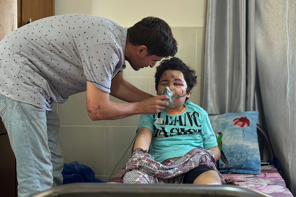 Een hulpverlener helpt een gewond kind in Gaza.