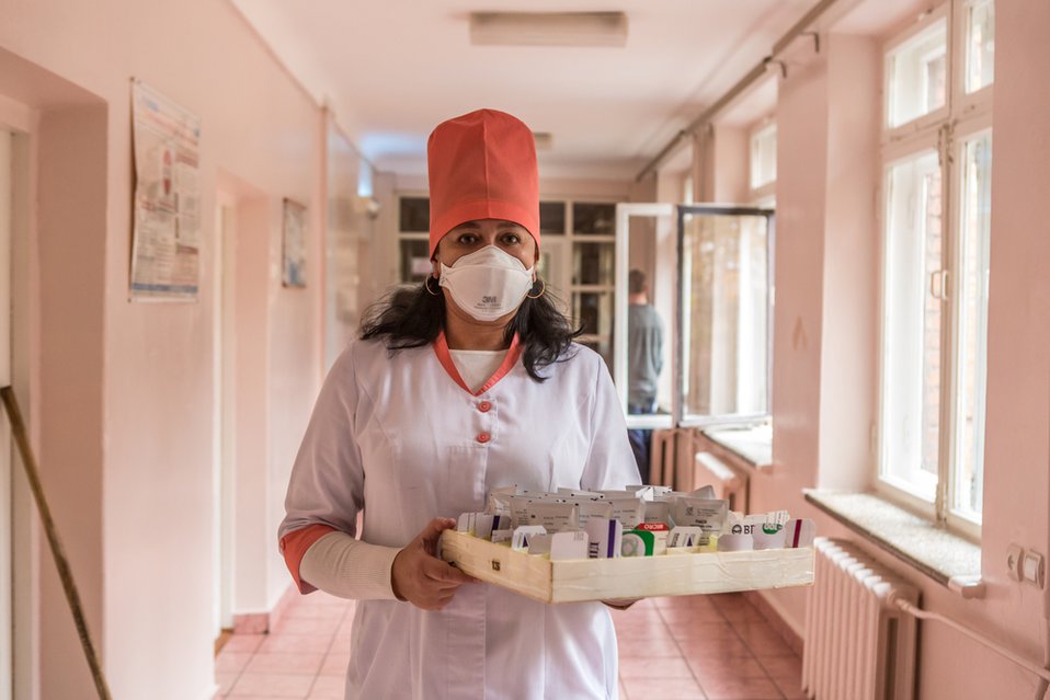 Verpleegkundige deelt pillen aan de patiënten met multiresistente tuberculose in Zhytomyr, Oekraïne