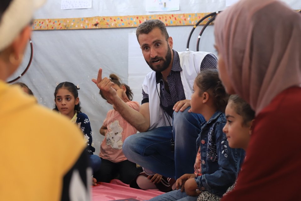 Een psycholoog van Artsen zonder Grenzen in gesprek met een groep kinderen en vrouwen in Gaza.