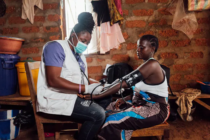 Verloskundige neemt de bloeddruk op van patient in mobiele kliniek in Sierra Leone