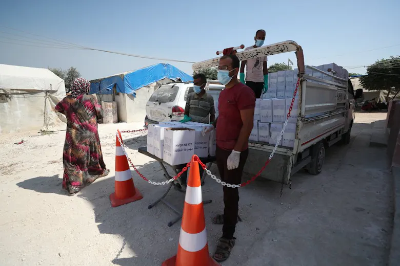 Medewerkers van Artsen zonder Grenzen delen hygiënekits uit in het Abu Dali vluchtelingenkamp in Syrië.