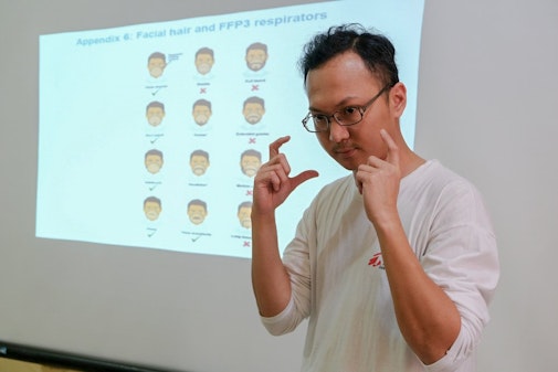 Onze hulpverlener geeft voorlichting over het gebruik van mondkapjes