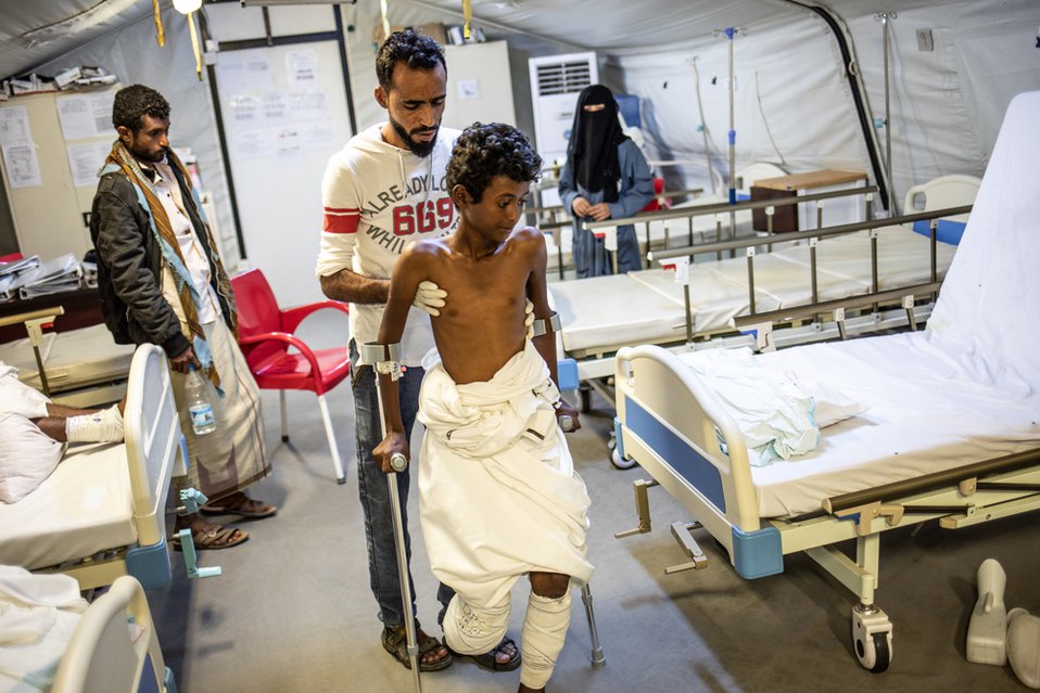 MSF fysiotherapeut Faroukin in het veldhospitaal in Jemen doet oefeningen met Nasser, die gewond raakte toen hij op een mijn stapte.
